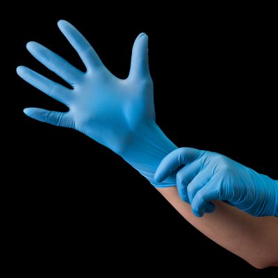 Doctor wearing a medical glove on hands isolated on black background with clipping path. Concept of protection against pandemic and viruses.